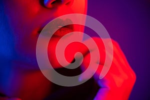 Close-up portrait of beautiful young woman with short hair in neon light. Girl with sensual lips in ultraviolet light.