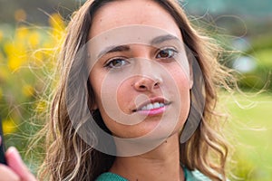 Close up portrait of beautiful young woman smiling in the garden