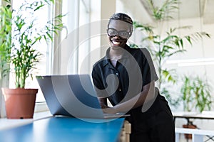 Close up portrait of a beautiful young woman smiling and looking at laptop screen