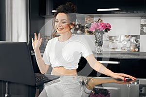 Close up portrait of beautiful young woman smiling and looking at laptop screen