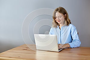 Close up portrait of a beautiful young woman smiling and looking at laptop screen