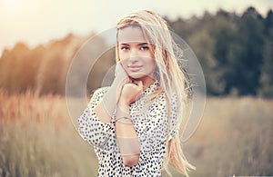 Close Up Portrait of beauty girl with fluttering white hair enjoying nature outdoors, on a field. Flying blonde hair on the wind