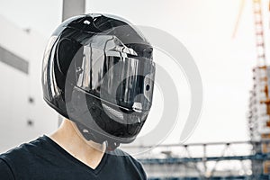 Close up portrait of biker in closed black glossy helmet