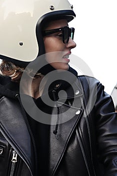 Close-up portrait of biker girl adjusting her white helmet.