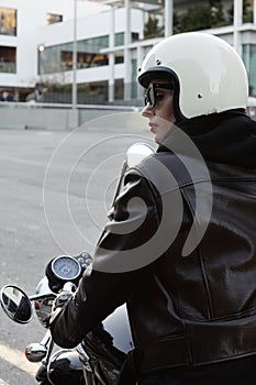 Close-up portrait of biker girl adjusting her white helmet.