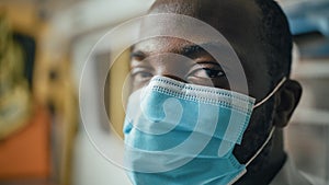 Close Up Portrait of a Black African American EMS Professional Paramedic Looks at Camera While Wea