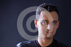 Close-up portrait of black-haired man on black background