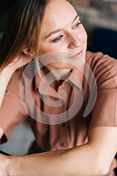 Close-up portrait of blonde woman sitting at chair in the living room.