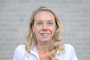 Close up portrait of an blonde woman smiling to the camera