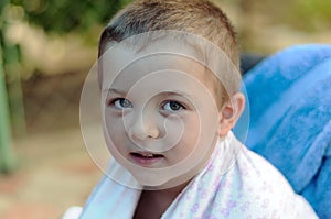 Close-up portrait of a boy wrapped in a towel