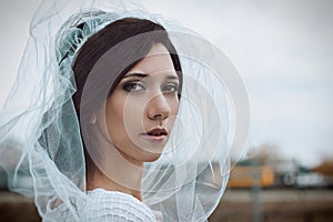 Close-up portrait of bride in white veil. Wedding photo.