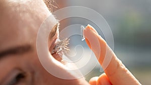 Close-up portrait caucasian woman putting on a contact lens.