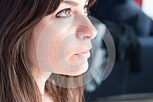 close up portrait of caucasian young woman with dark hair and eyes. Profile