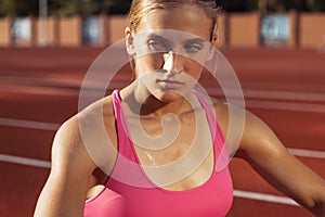 Close-up portrait of Caucasian young woman, female athlete, runner at public stadium, sport court or palyground outdoors