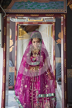 Close up portrait charming Asian woman wearing a traditional saree looking at down hile traveling in Wat Pra Kaew in Thailand photo