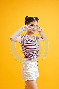 Close-up portrait of charming woman with colorful eyeshadows. Girl cute smiling on yellow background