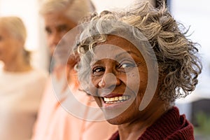 Close-up portrait of cheerful african american senior woman with multiracial friends in nursing home