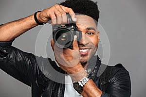 Close-up portrait of cheerful african man looking through camera