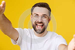 Close up portrait of a cheerful bearded man taking selfie over white background.