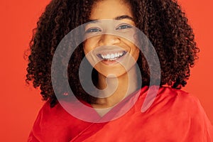 Close up of portrait of cheerful beautiful young girl with afro hairstyle in red casual clothes