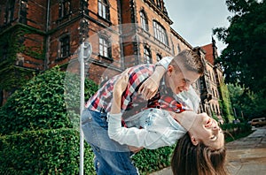Close-up portrait of the cheerful loving couple dancing in the green street of Poland.