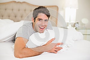 Close up portrait of a cheerful man resting in bed