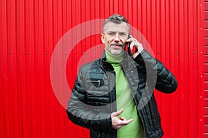 Close up portrait of a cheerful middle aged man with beard standing against the wall and smiling  Portrait of a mature man