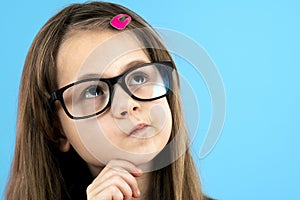 Close up portrait of a child school girl wearing looking glasses holding hand to her face thinking about something isolated on