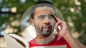 Close-up portrait concentrated bearded Middle Eastern student memorizing material reading book talking in slow motion