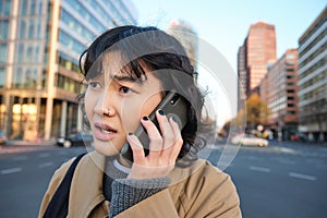 De cerca retrato preocupado asiático una mujer conversaciones sobre el móvil teléfono a escucha malo apariencia preocupado siente frustrado de acuerdo a 