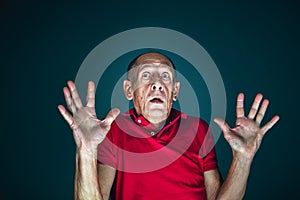 Close up portrait of crazy scared and shocked man isolated on dark background