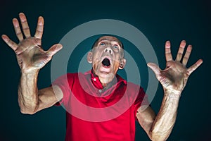 Close up portrait of crazy scared and shocked man isolated on dark background