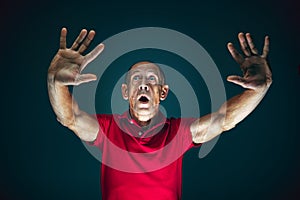 Close up portrait of crazy scared and shocked man isolated on dark background