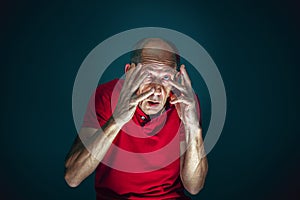 Close up portrait of crazy scared and shocked man isolated on dark background