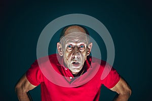 Close up portrait of crazy scared and shocked man isolated on dark background