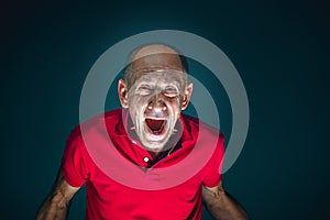 Close up portrait of crazy scared and shocked man isolated on dark background