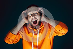 Close up portrait of crazy scared and shocked man isolated on dark background