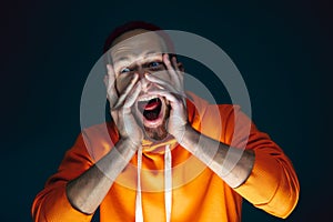 Close up portrait of crazy scared and shocked man isolated on dark background