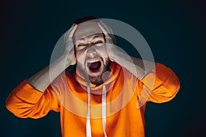 Close up portrait of crazy scared and shocked man isolated on dark background