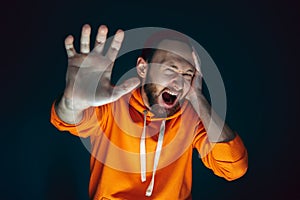 Close up portrait of crazy scared and shocked man isolated on dark background