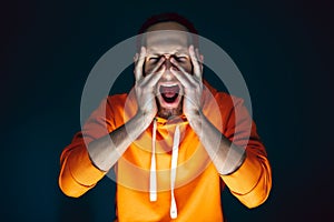 Close up portrait of crazy scared and shocked man isolated on dark background