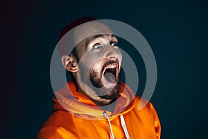 Close up portrait of crazy scared and shocked man isolated on dark background