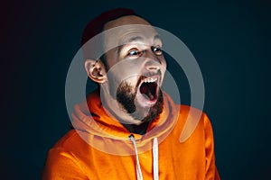 Close up portrait of crazy scared and shocked man isolated on dark background