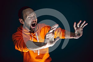 Close up portrait of crazy scared and shocked man isolated on dark background