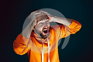 Close up portrait of crazy scared and shocked man isolated on dark background