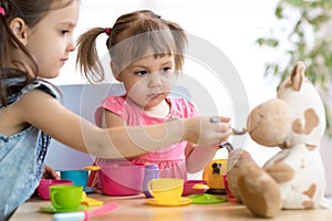 Close-up portrait of cute adorable little kids feeding caw plush toy