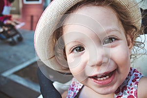 Close-up portrait of cute baby girl looking at camera wearing a hat