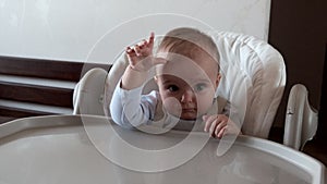 Close-up portrait of cute baby girl sitting on a chair for babies.