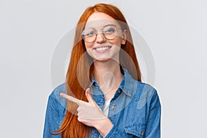 Close-up portrait cute cheerful redhead, foxy girl in glasses, showing place to click website, follow or subscribe