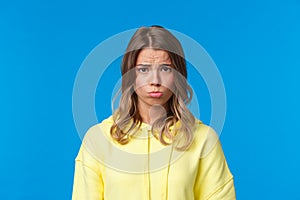 Close-up portrait cute gloomy and upset sulky blond girl with short haircut, sobbing and pouting frowning distressed